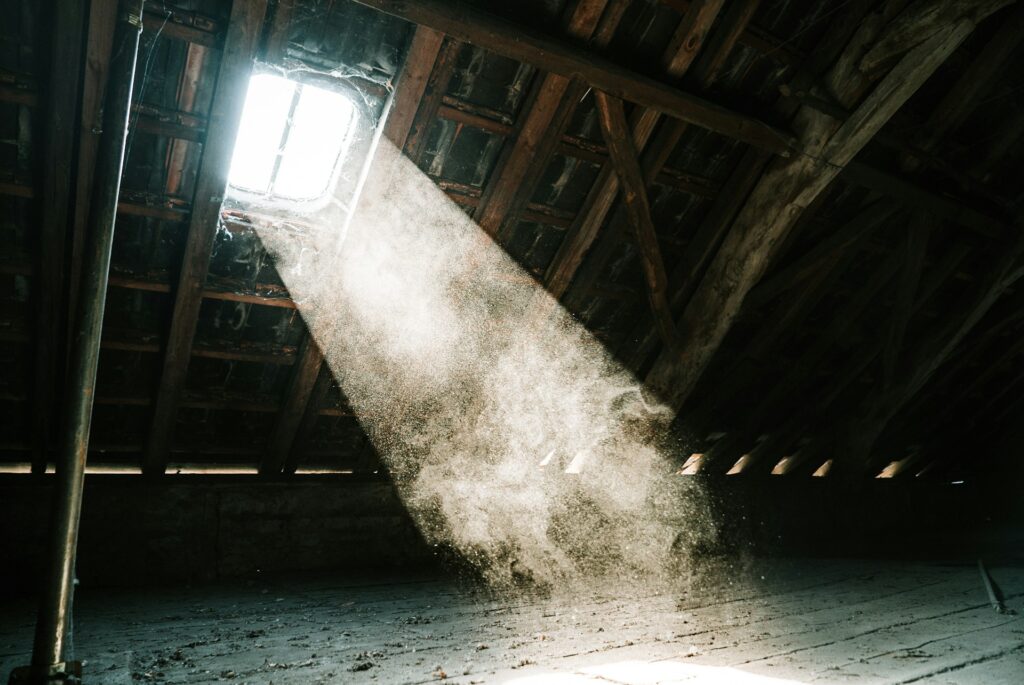 Ray of light full of dust particles within an attic.
