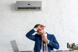 Businessman in warm office that requires hvac repair