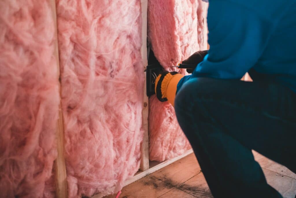 Person installing energy efficiency insulation in the wall.