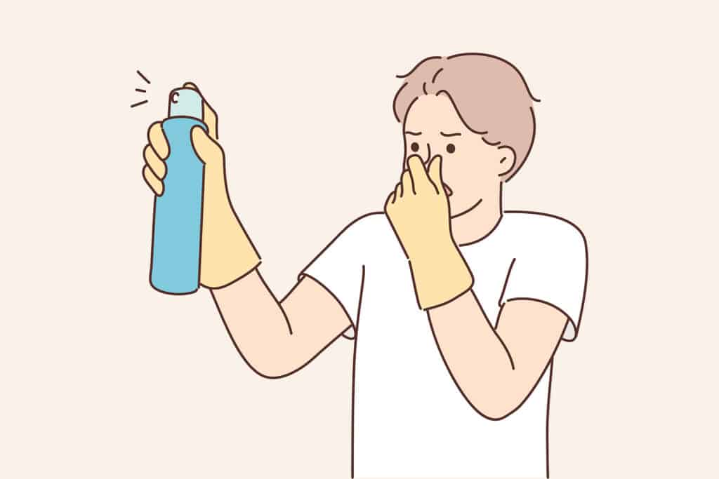 Simple Cartoon of a person experiencing a bad smell and holding their nose while spraying disinfectant.
