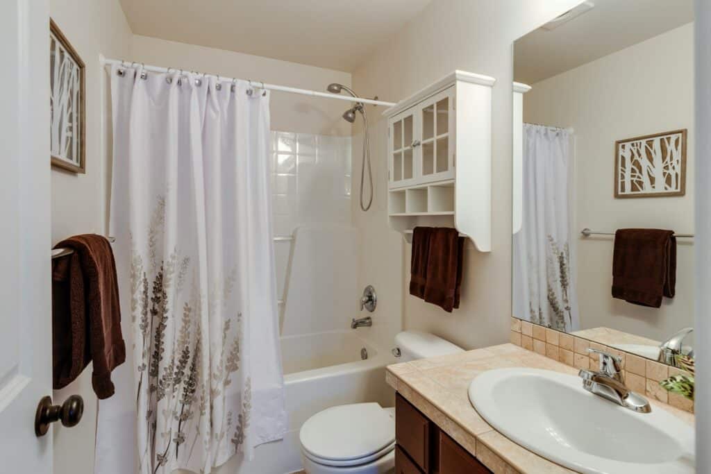Bathroom with sink, mirror, toilet, and shower.