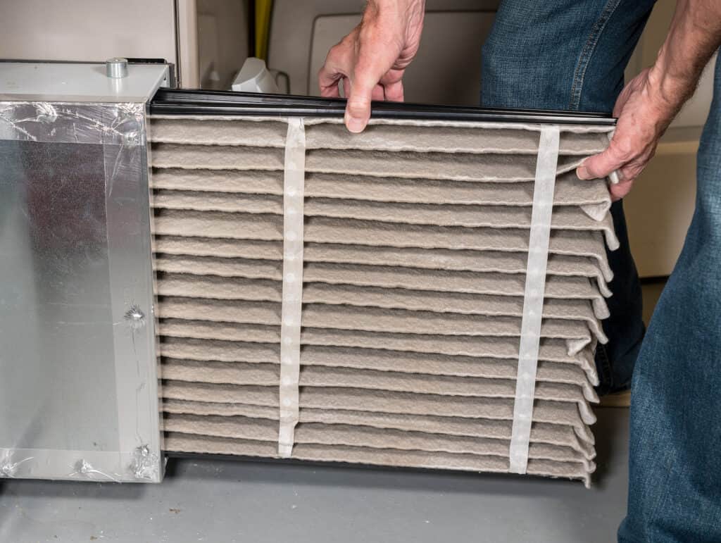 Dirty central air filter being replaced.