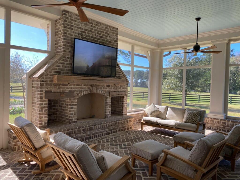 Large Sunroom with dual fans, fireplace, ceiling fans, and large tv.
