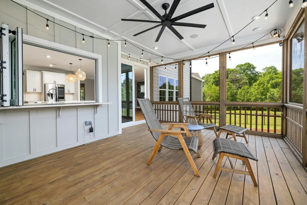 Screened in porch with bar, ceiling fan, and lounge chairs.