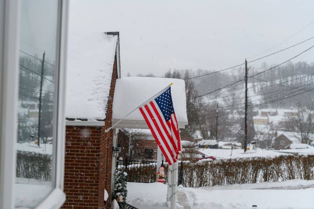 Suburban home with snow covered roof and porch.