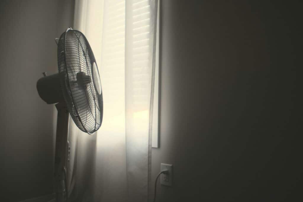 Stand up fan being used to cool hot second floor bedroom.